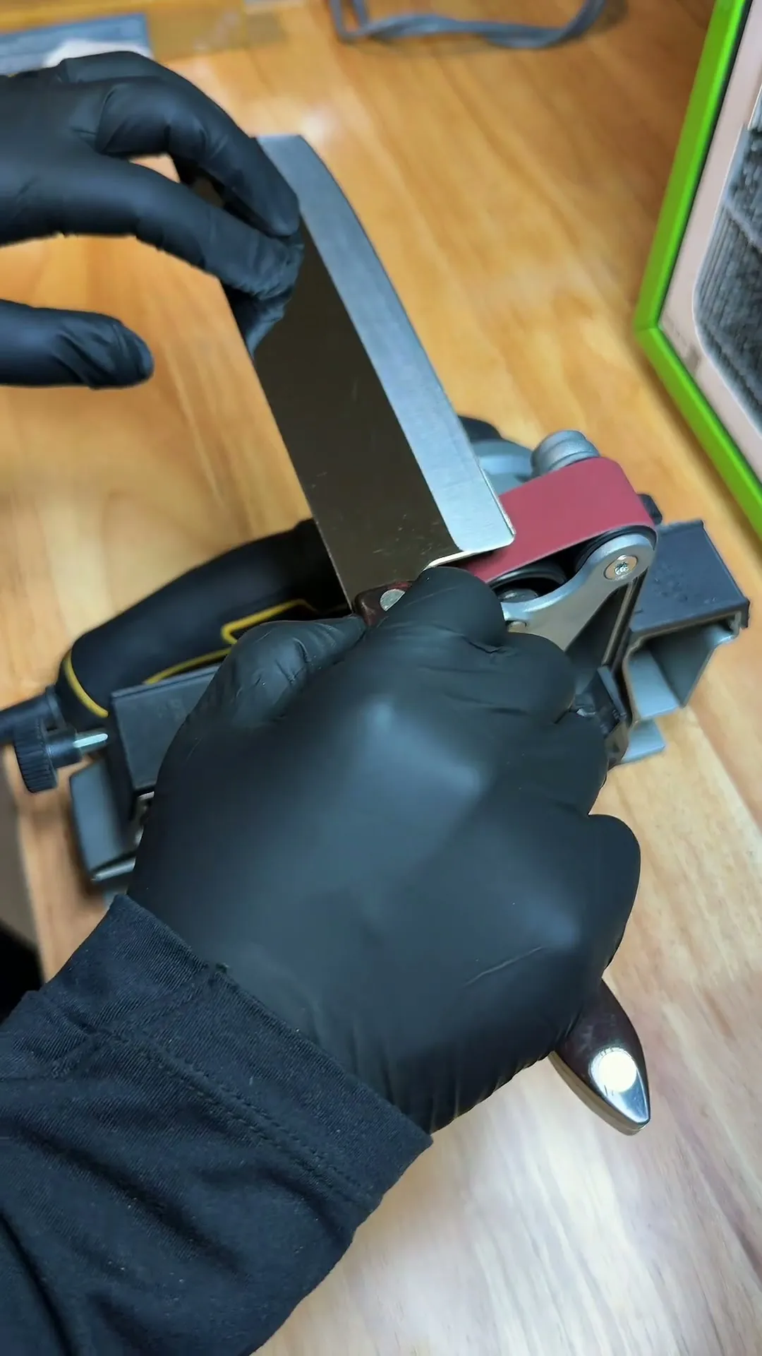 Erick wearing black gloves while sharpening a knife on his compact sharpening setup
